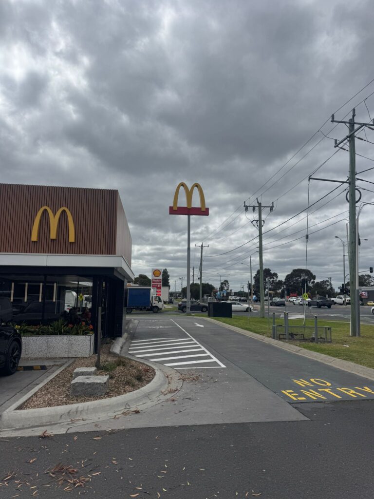 McDonald’s restaurant under stormy skies with nearby damage cleanup.